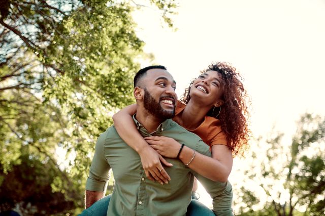 Attractive Black couple embracing and walking in nature