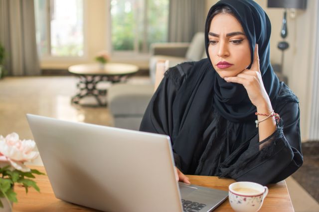 Muslim woman researches on a computer