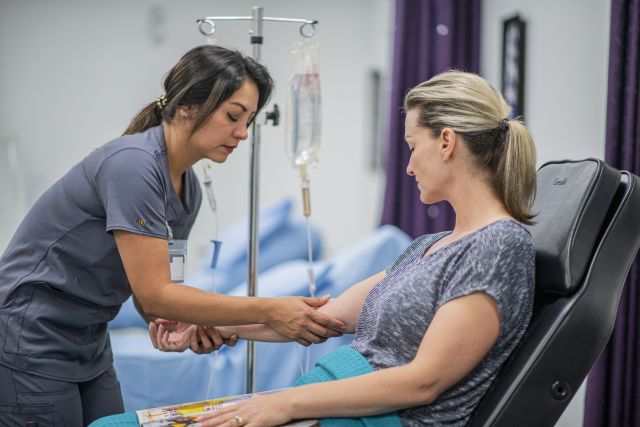 Woman giving another woman an IV