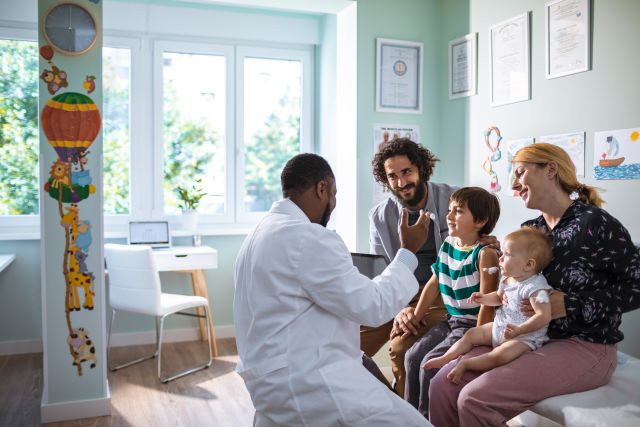 a happy family with two children visits the pediatrician's office