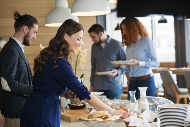 a group of young adults enjoys sampling items from a holiday breakfast buffet