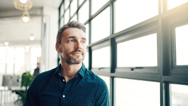 Man sits and looks out window.