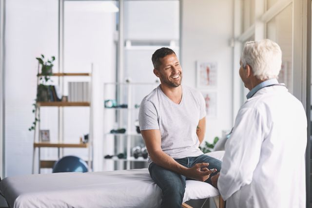 Young man with senior doctor in office