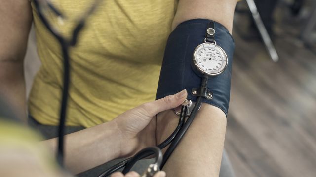 A young woman has her blood pressure read. Hypertension is a possible long-term complication of AIP.