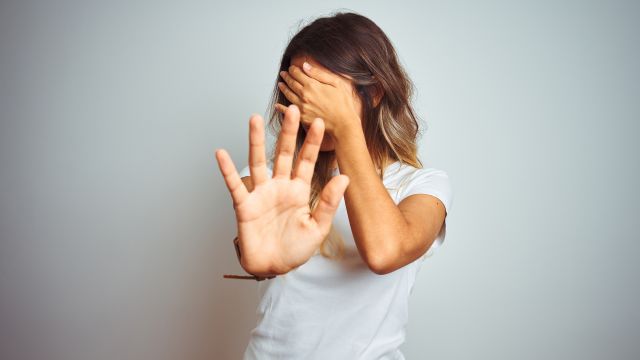 A woman covers her face because she is embarrassed by facial psoriasis. Up to 20 percent of people with plaque psoriasis experience psoriasis on the face.