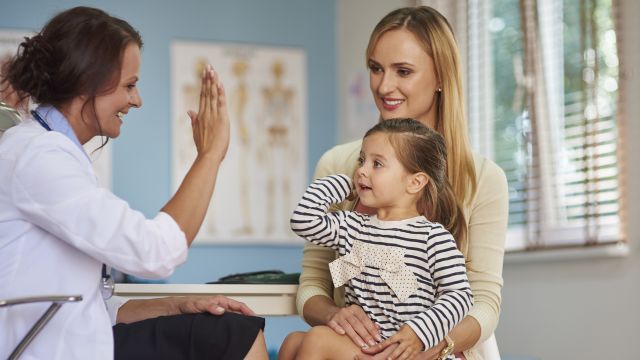 A parent and child meet with a pediatrician. 