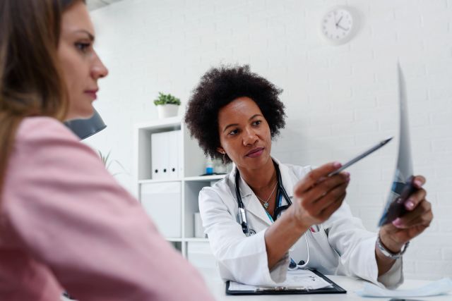 Female doctor looking at test results of her patient.