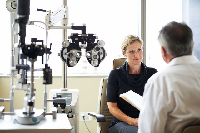 A woman listens to her opthamologist 