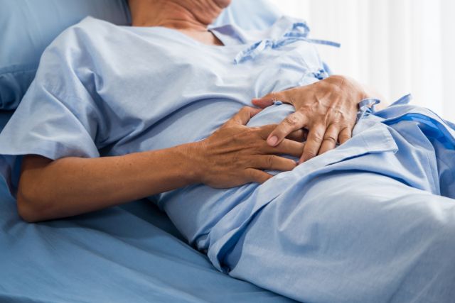 man in hospital bed with abdominal stomach pain