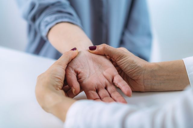 A neurologist examines a female patient during an appointment for an evaluation for ATTR amyloidosis.