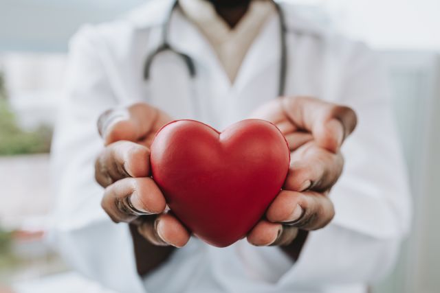 Healthcare provider holding up a red heart