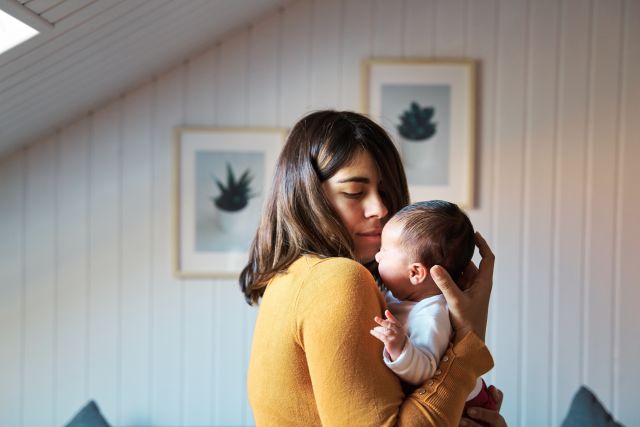 a young Latina woman cradles her crying baby