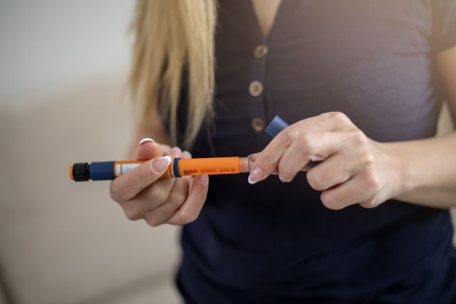 someone holding an insulin injection pen