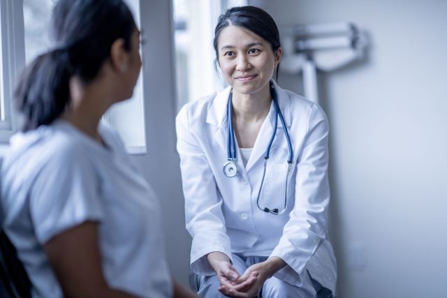 young woman doctor talking to patient
