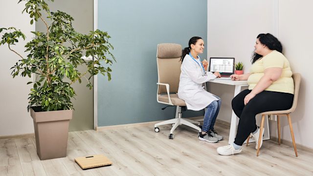 A young woman speaks with a healthcare provider about weight loss treatment during an appointment.