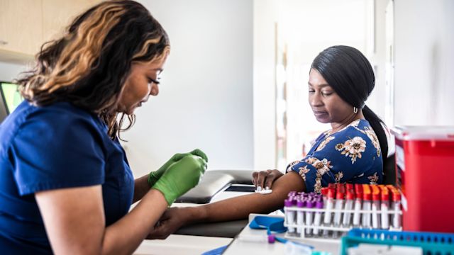 A healthcare provider draws a woman's blood for hepatitis C testing. Blood work is important to diagnosing hep C and monitoring response to treatment.