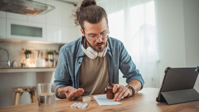 A man reads the instructions on a prescription medication. Treatment for IgAN often includes medications to reduce proteinuria and high blood pressure.