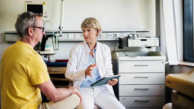 A senior man talks with one of his healthcare providers during a checkup. Communication is essential to successful treatment of any health condition, and challenges with communication are a barrier to care for many people.