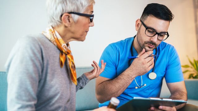 A senior woman speaks with one of her oncologists about instructions for taking an oral medication. Many targeted therapies are taken as oral medications.