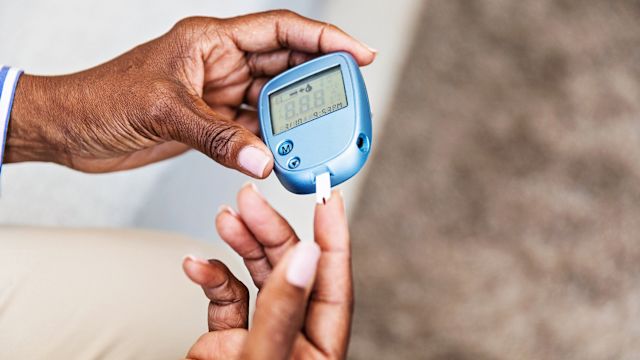 A diabetes patient tests her blood sugar. Diabetes is a risk factor for heart disease and cardiac events.