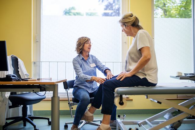 mature woman patient talking to healthcare provider about knee pain