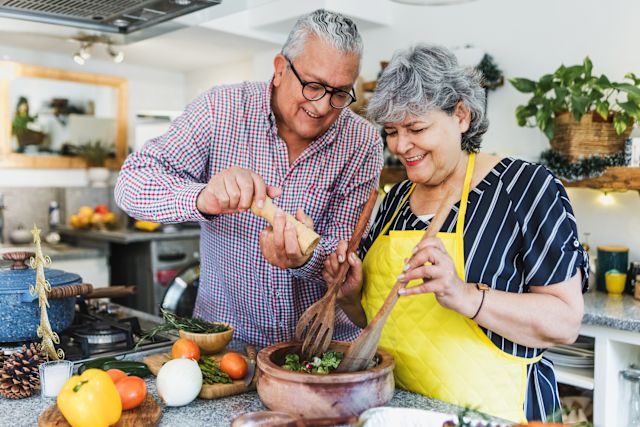 older adult couple preparing healthy food in kitchen