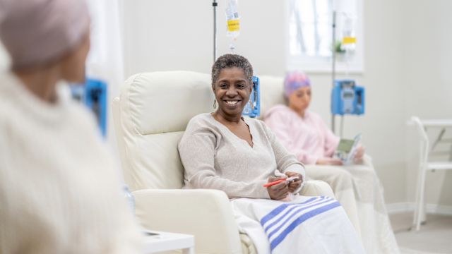 A group of women talk and offer each other support at an infusion center where they are receiving chemotherapy for breast cancer.