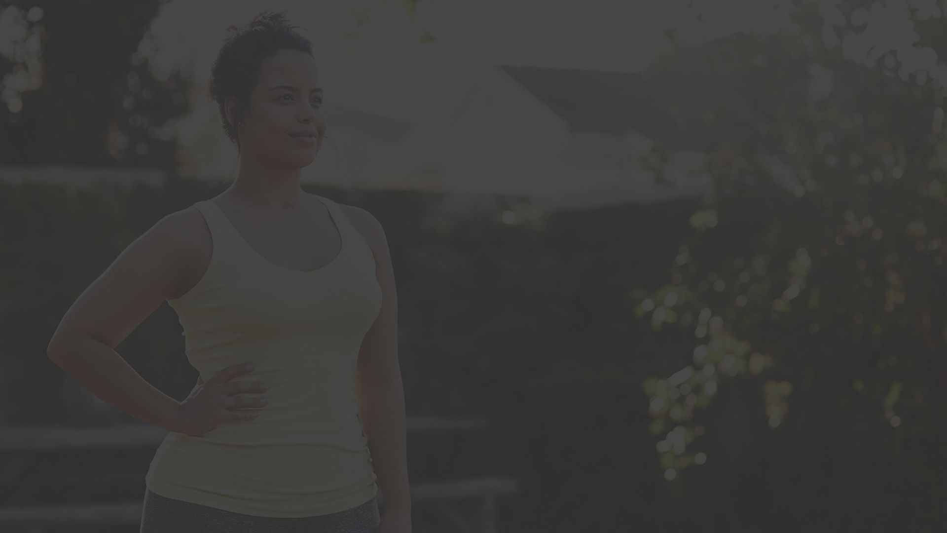 woman standing outside, exercising. 