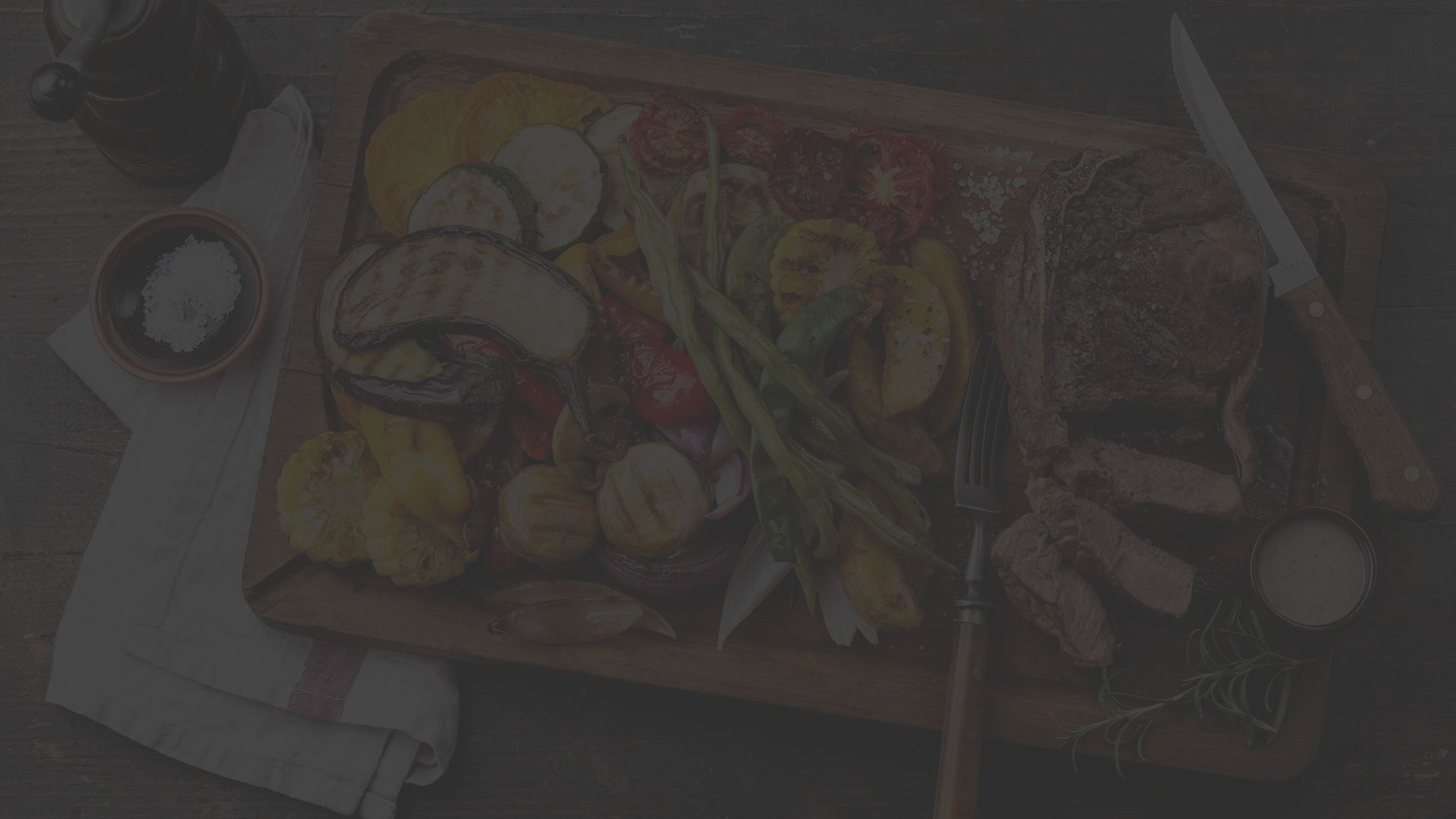 A cutting board filled with paleo-friendly foods, including plenty of vegetables and protein.